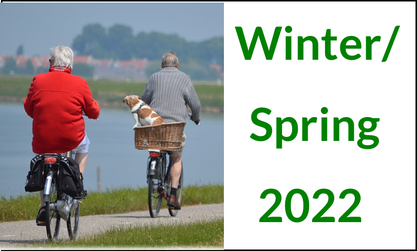 Winter/Spring 2022 elderly couple riding bikes with a dog on the back of a bike in a basket