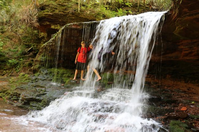 Youth behind a waterfall